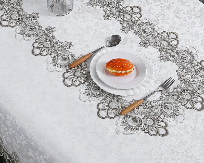 White lace embroidery tablecloth with intricate floral patterns and scalloped edges. Ideal for dining tables, weddings, and special occasions.