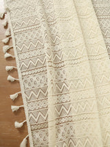 Beige lace tablecloth with a wave pattern and tassels for a sophisticated dining setup