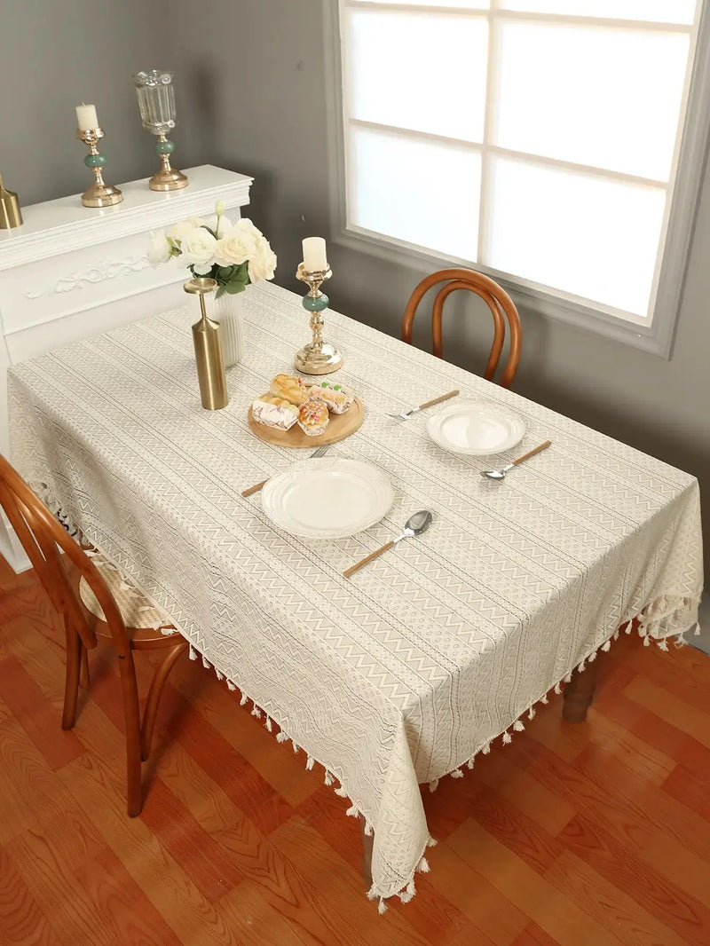 Stylish beige lace tablecloth with a wave pattern and tassels, perfect for home decor.