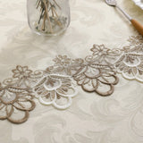 White lace embroidery tablecloth with intricate floral patterns and scalloped edges. Ideal for dining tables, weddings, and special occasions.