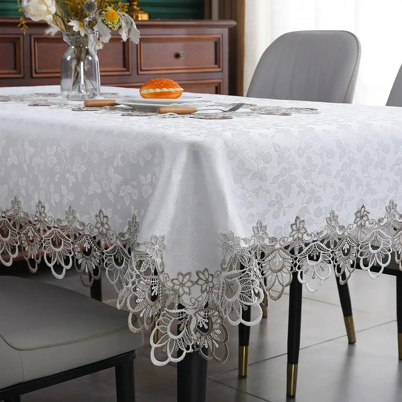 White lace embroidery tablecloth with intricate floral patterns and scalloped edges. Ideal for dining tables, weddings, and special occasions.