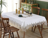 Ivory lace embroidery tablecloth with floral patterns on a dining table. Elegant and waterproof, suitable for weddings and home decor.