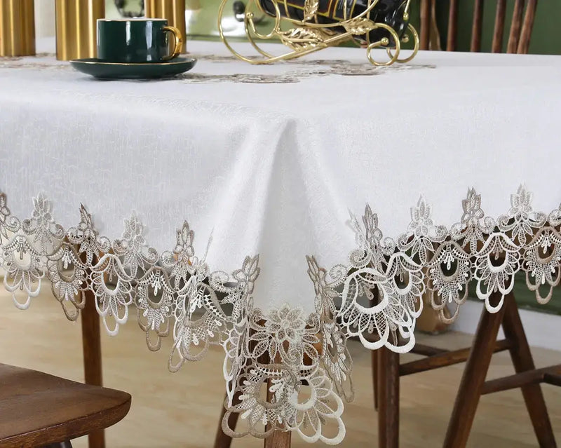 Ivory lace embroidery tablecloth with floral patterns on a dining table. Elegant and waterproof, suitable for weddings and home decor.