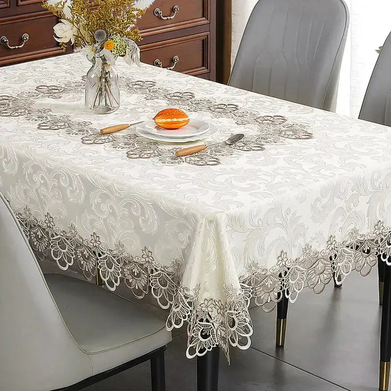 Ivory lace embroidery tablecloth with floral patterns on a dining table. Elegant and waterproof, suitable for weddings and home decor.