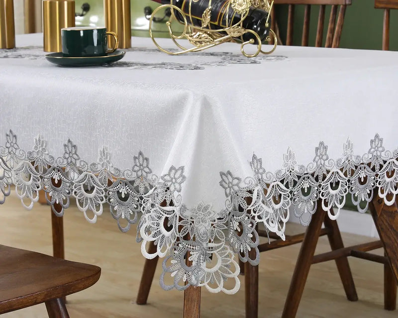  Ivory lace embroidery tablecloth with floral patterns on a dining table. Elegant and waterproof, suitable for weddings and home decor.