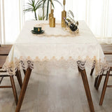 White lace embroidery tablecloth with intricate floral patterns and scalloped edges. Ideal for dining tables, weddings, and special occasions.